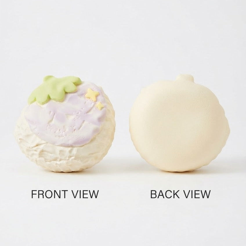 A two-view product shot on a white background showing the front and back of a small decorative item. The front view is textured off-white with a pale lavender top and a light green leaf detail, while the back view is smooth and solid off-white.