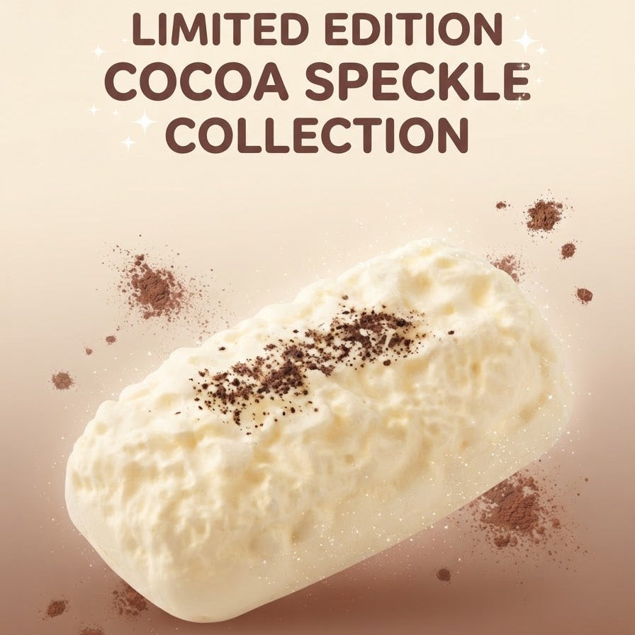 A single frosted white chocolate bar with cocoa speckles, set against a warm brown gradient background with the text 'LIMITED EDITION COCOA SPECKLE COLLECTION' at the top.
