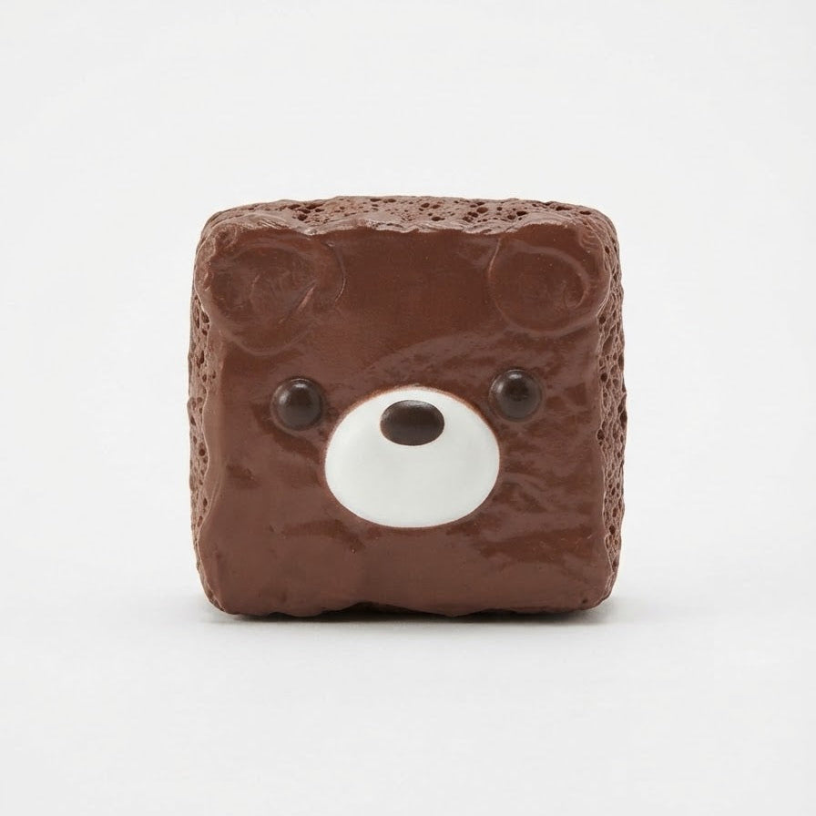 A square brown bear-face object with a textured surface, small black eyes, and a white snout, centered on a plain white background.