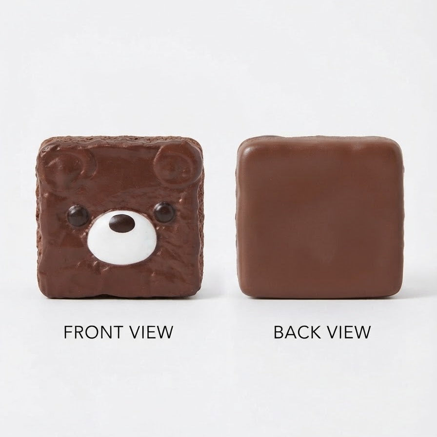 A square brown chocolate-like item shown from front and back on a light gray background. The front view has a bear face design with small black eyes and a white snout, while the back view is plain brown.
