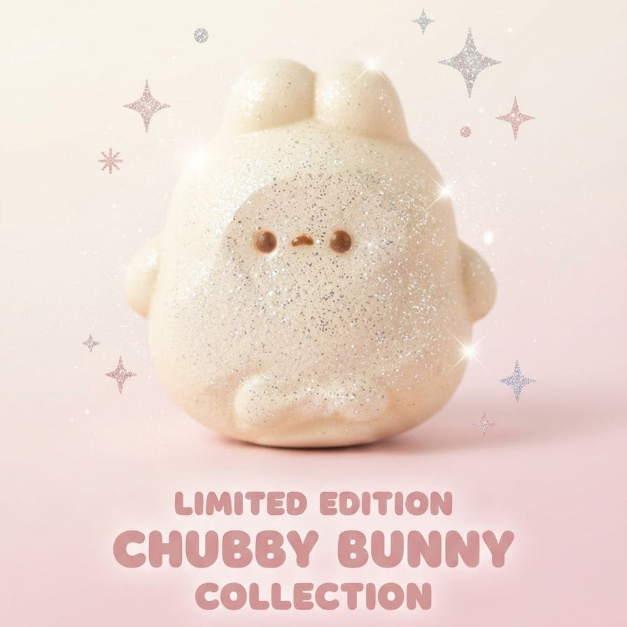 A cute, rounded beige bunny figurine with tiny brown eyes and mouth, covered in fine glitter, set against a soft pink gradient background with decorative sparkles and the text 'LIMITED EDITION CHUBBY BUNNY COLLECTION'.