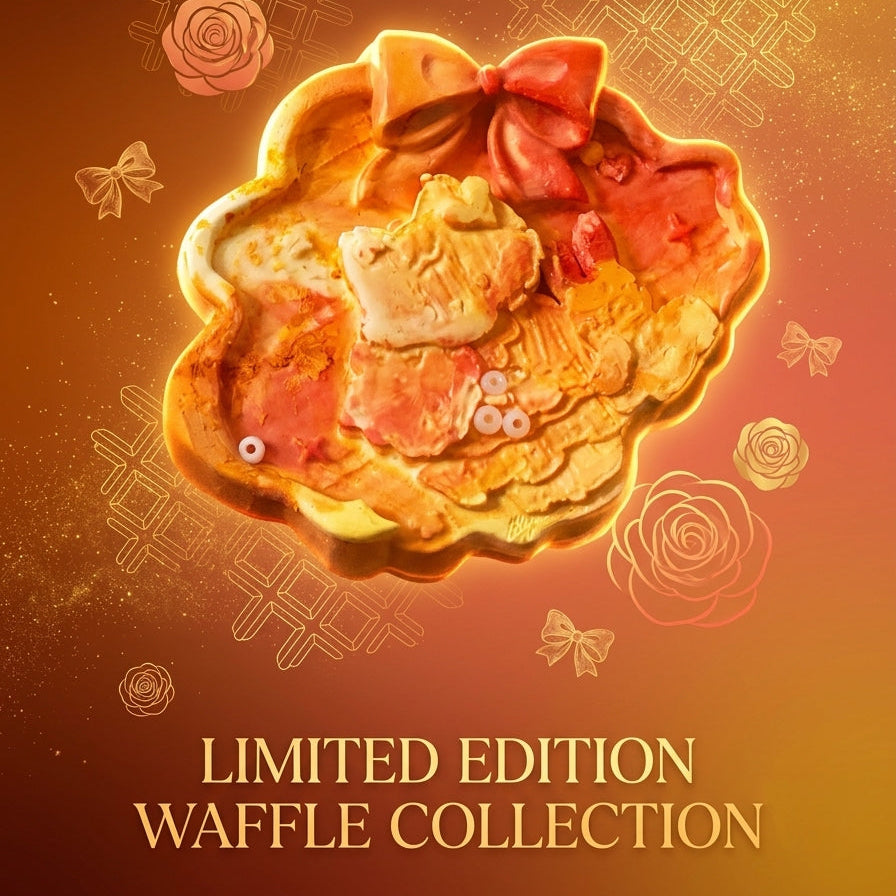 A decorative waffle-shaped pastry or dessert with pink and cream filling, topped with a pink bow, centered on a warm brown and orange gradient background with gold floral and bow illustrations and the text 'LIMITED EDITION WAFFLE COLLECTION' at the bottom.