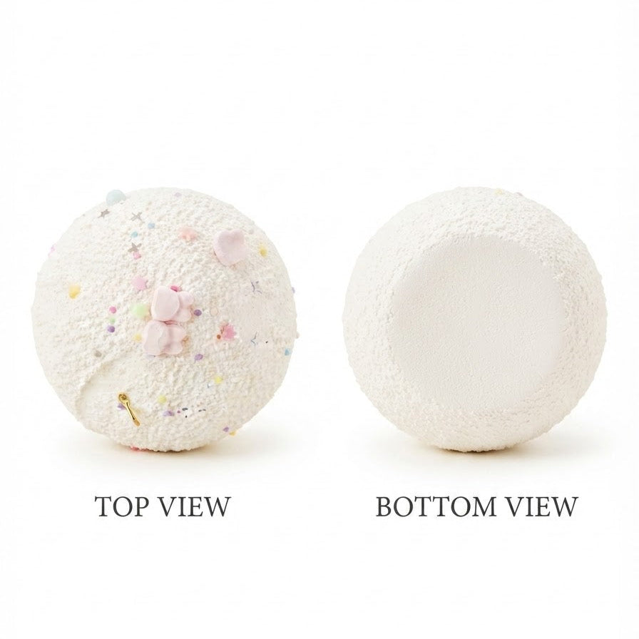 Two textured white spherical objects shown on a white background, labeled TOP VIEW and BOTTOM VIEW. The left sphere has a speckled pastel pattern with small pink and yellow details, and the right sphere is plain white.