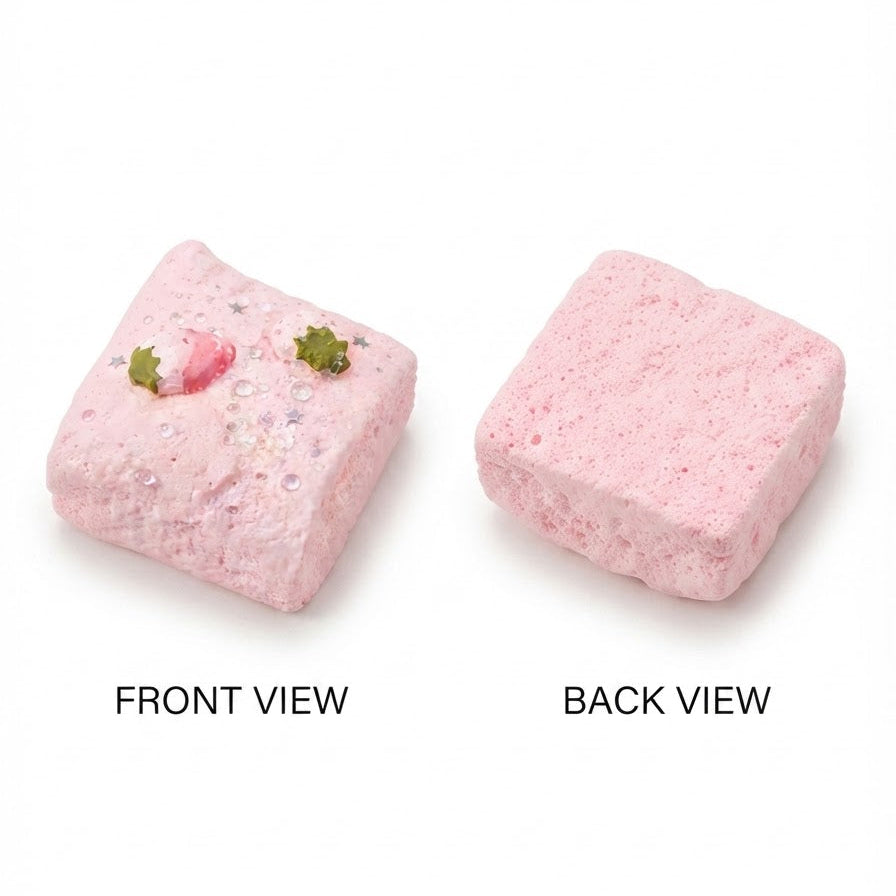 Two pink bath bomb blocks shown on a white background, labeled FRONT VIEW and BACK VIEW. The left block has small green and pink decorative details, and both pieces appear textured and porous.