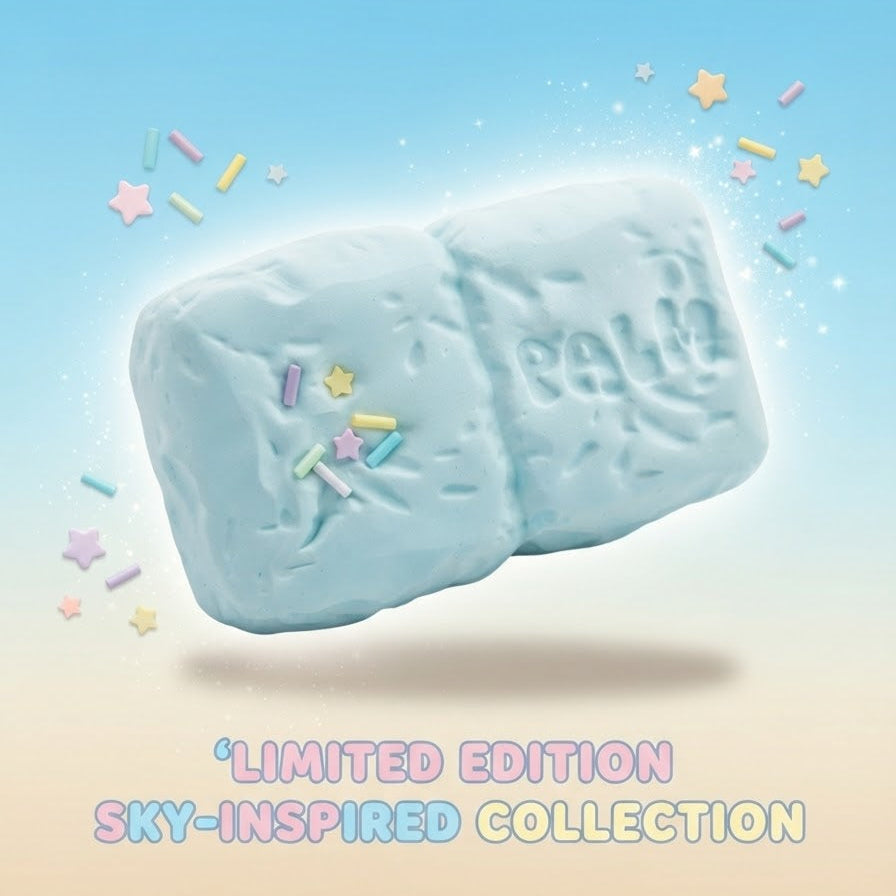 A light blue, cloud-shaped bath bomb with the brand name 'Balm' embossed on one side, floating against a pastel blue-to-beige gradient background with colorful star and sprinkle decorations. Text at the bottom reads 'LIMITED EDITION SKY-INSPIRED COLLECTION'.