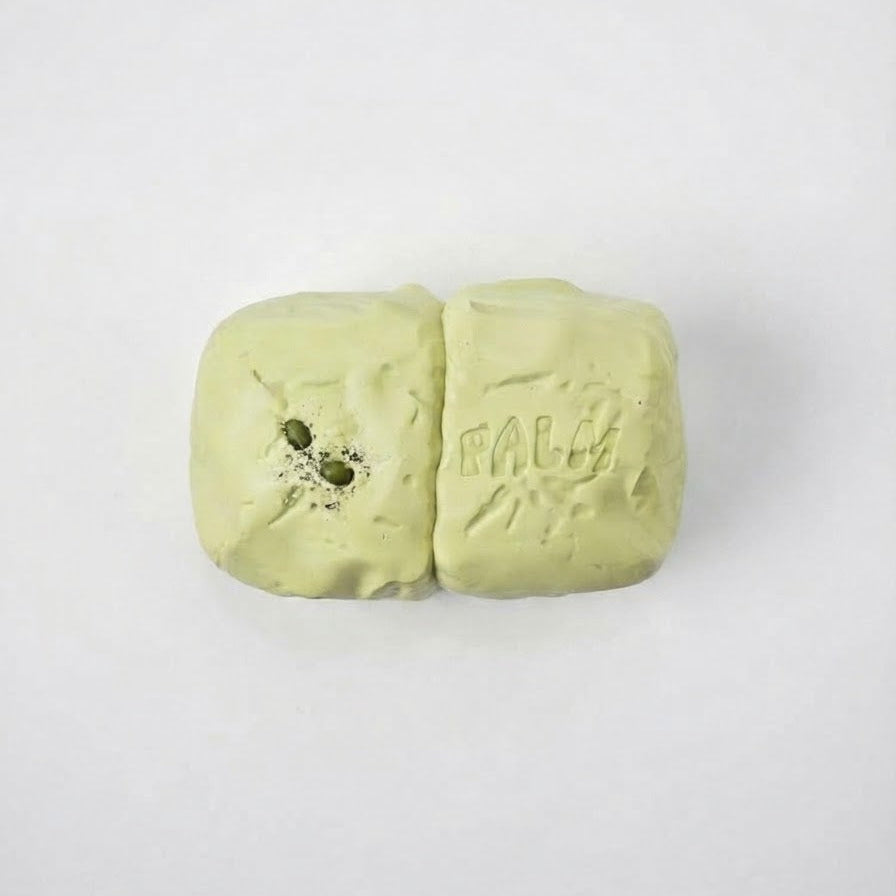 A pale yellow-green clay bar with the brand name 'FALCA' embossed on one side and a small green botanical illustration on the other, shown on a plain white background.