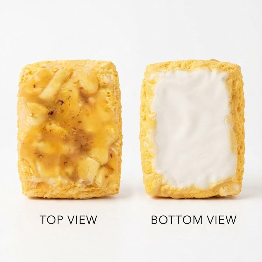 Two square yellow marshmallow-style treats shown on a white background, labeled TOP VIEW and BOTTOM VIEW. The left treat shows a golden marshmallow top with small darker flecks, and the right treat shows a white marshmallow center surrounded by a golden yellow base.