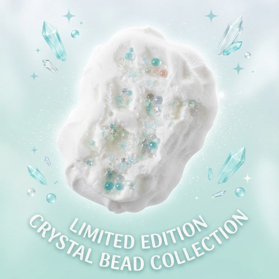A white, cloud-like decorative object with embedded translucent blue and green crystal beads, centered on a pale mint background with floating crystal graphics and the text 'LIMITED EDITION CRYSTAL BEAD COLLECTION' below.