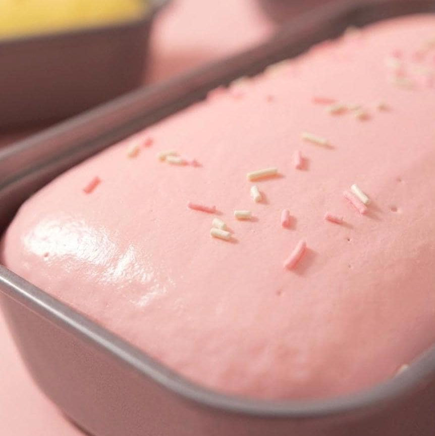 Pink cake with sprinkles in a baking pan