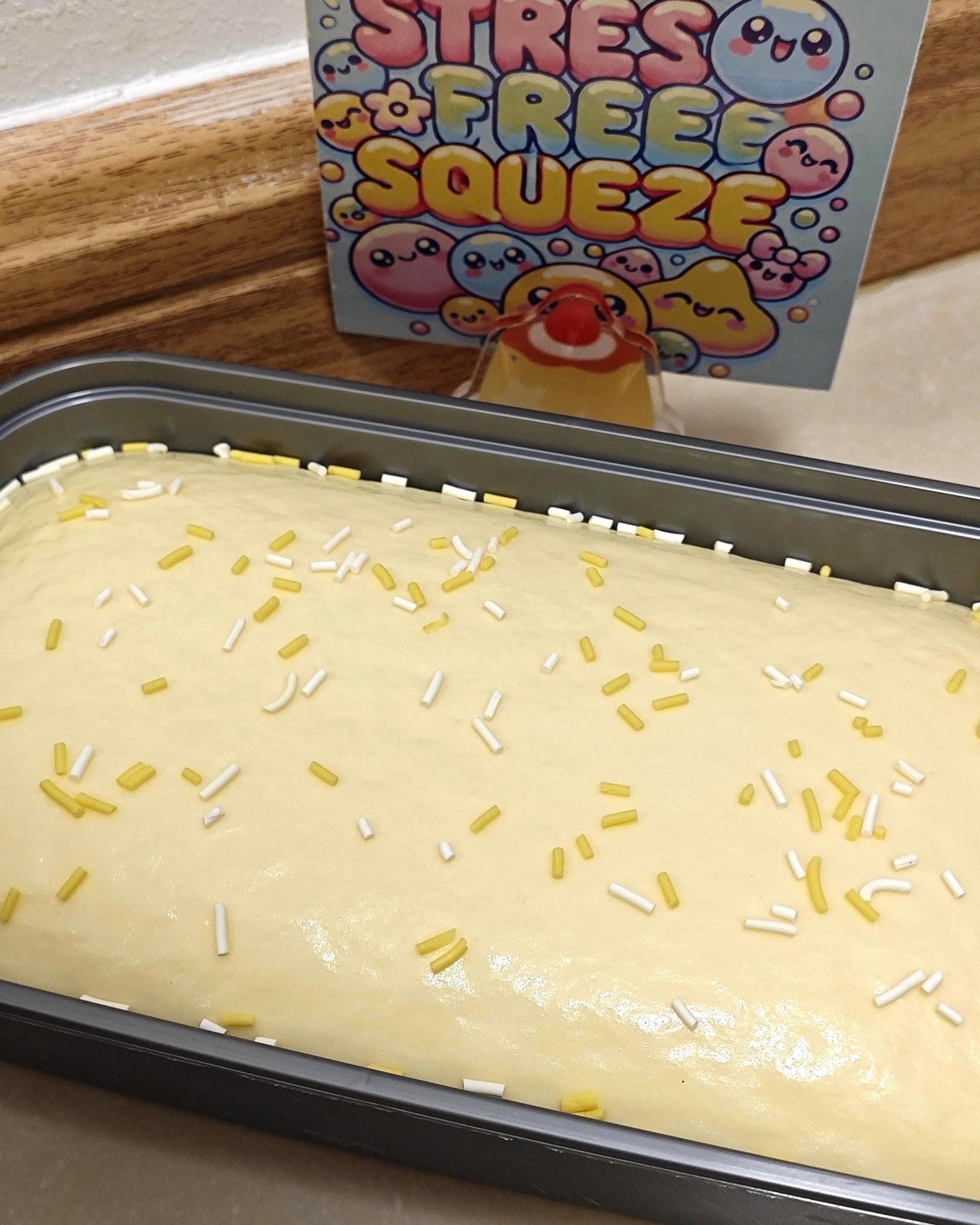 Baked good with sprinkles in a pan next to a box labeled 'Stress Free Squeeze'.