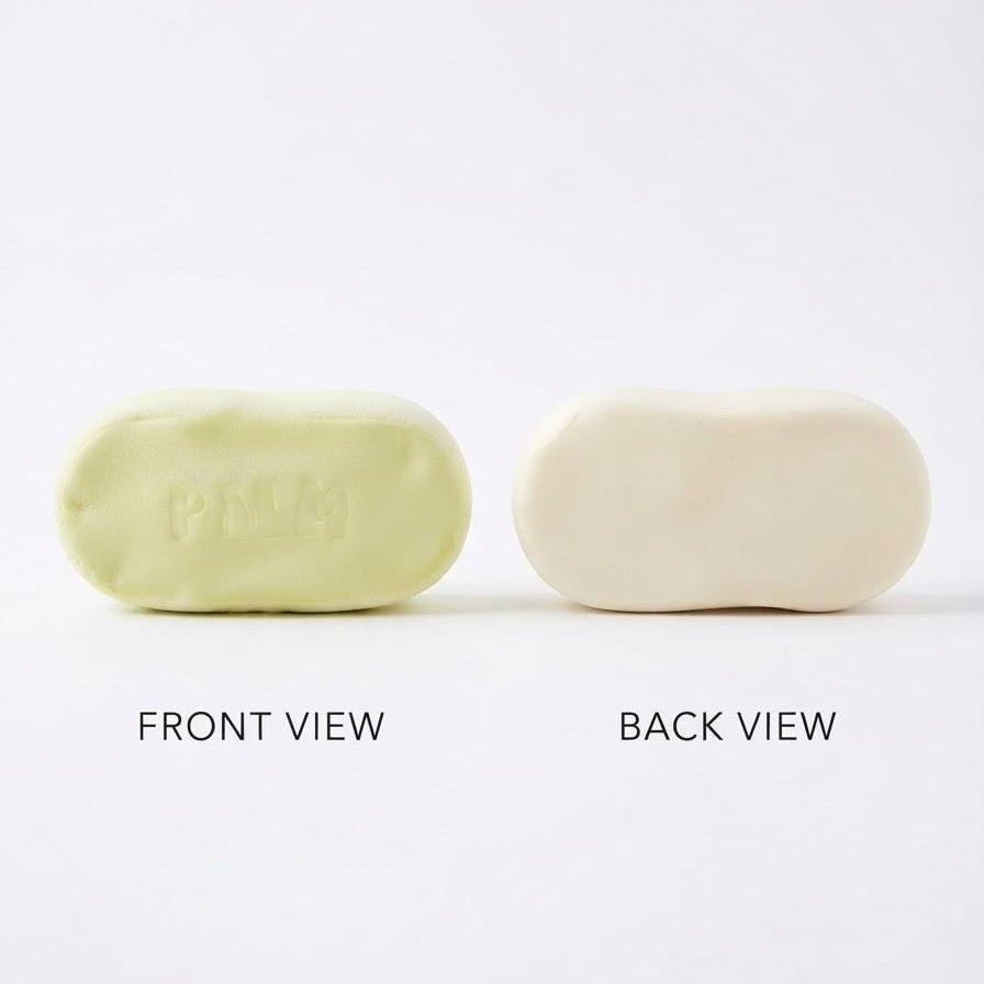Two oval-shaped soap bars shown side by side on a white background, labeled 'FRONT VIEW' and 'BACK VIEW'. The left soap is pale yellow-green with 'PILM' embossed on top, and the right soap is off-white/cream.