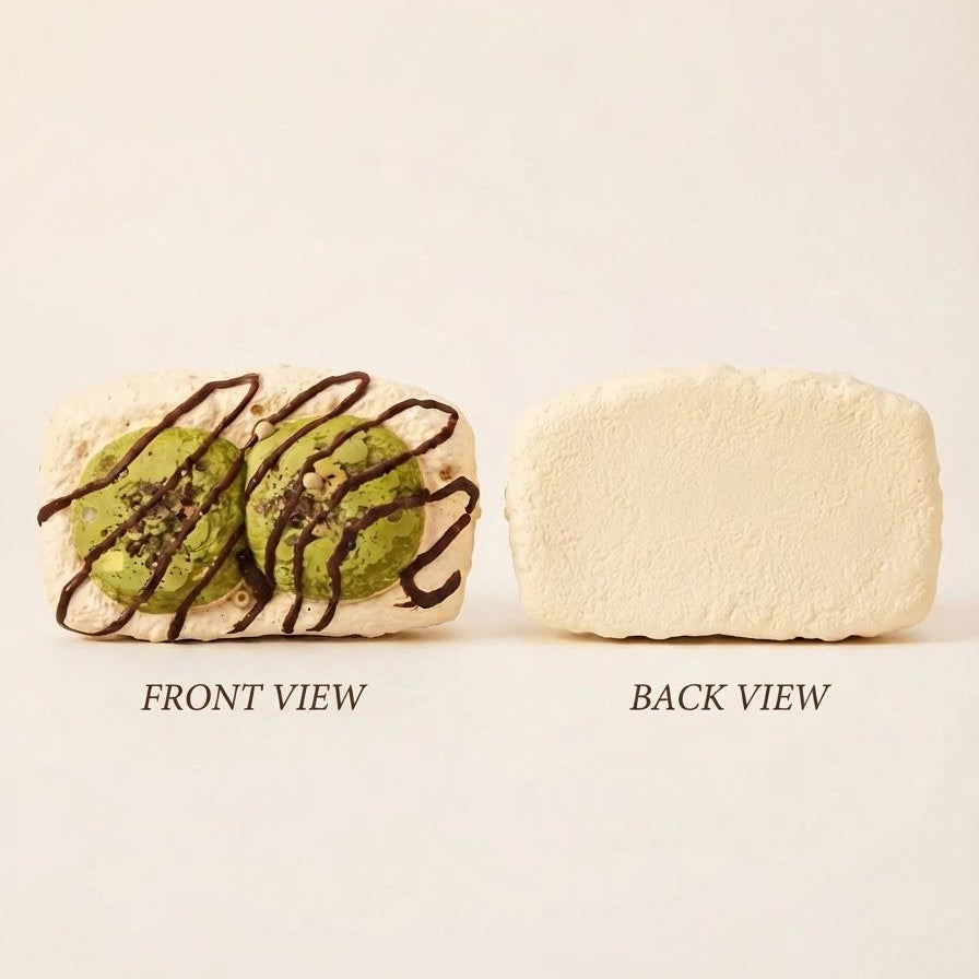 A rectangular cream-colored baked good or pastry shown from two angles on a plain light background. The left side is labeled FRONT VIEW and shows the pastry with two green round centers and dark chocolate drizzle.